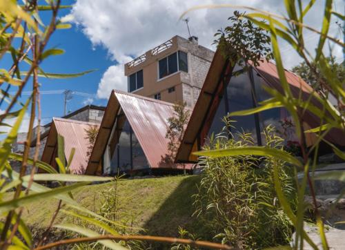 una casa con techo de metal en Glamping Campo Lago San Pablo, en Otavalo