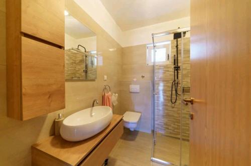 Gornji ZemunikにあるFamily friendly house with a swimming pool Zemunik Donji, Zadar - 21653の白い洗面台とシャワー付きのバスルーム
