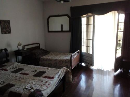een slaapkamer met 2 bedden, een spiegel en een raam bij MG - Aluguer de quartos in Felgueiras