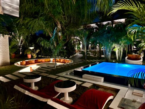 een zwembad in het midden van een tuin met palmbomen bij Lukas Garden Accra in Accra