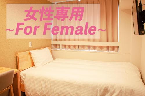 a bedroom with a bed and a sign for feminism at Sauna & Cabin Thermae-yu Nishiazabu in Tokyo
