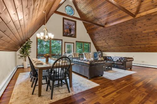 a dining room and living room with a wooden ceiling at Star Gazer Luxury A-Frame Wood Cabin. Near York/Harrisburg/Hershey/Lancaster in Goldsboro