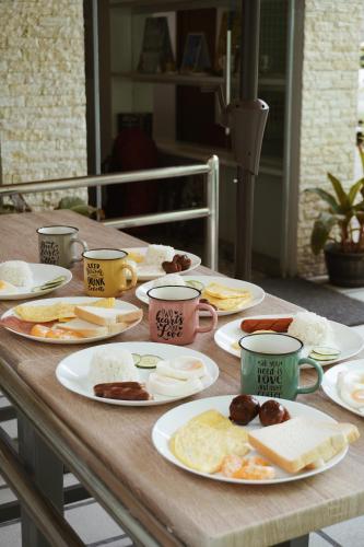 a wooden table with plates of breakfast food on it at Cebu Backpackers Hostel in Cebu City