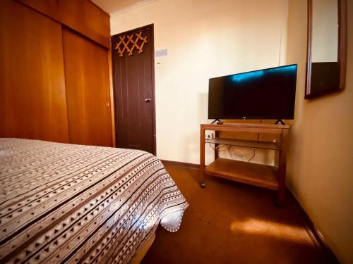 1 dormitorio con 1 cama y TV de pantalla plana en Residencial Italiana, en Los Andes