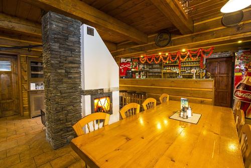 une salle à manger avec une table en bois et une cheminée dans l'établissement Horská chata Skácelka, à Rokytnice nad Jizerou