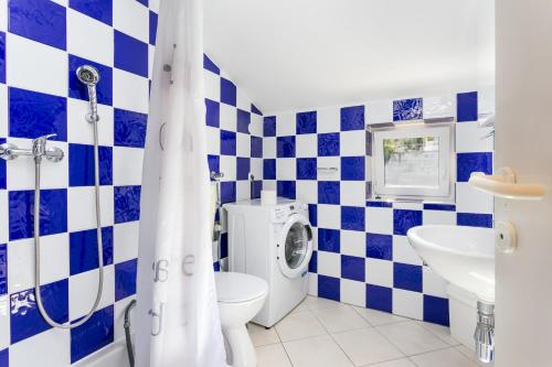 Un baño azul y blanco con inodoro y lavabo. en Apartment Seget Vranjica 14409a, en Donji Seget