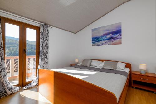 a bedroom with a bed and a large window at Apartments by the sea Duga Luka - Prtlog, Labin - 2335 in Labin