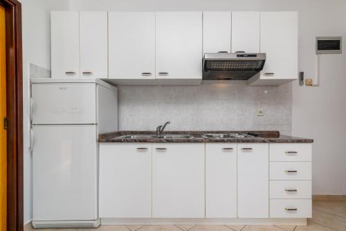 a white kitchen with white cabinets and a sink at Apartments by the sea Duga Luka - Prtlog, Labin - 2335 in Labin