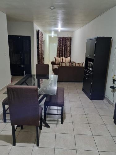 a living room with a glass table and chairs at Departamento Victoria in Saltillo