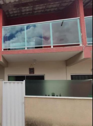 a building with glass windows on the side of it at Casa Duplex Arraial do Cabo 30 metros do Mar in Arraial do Cabo