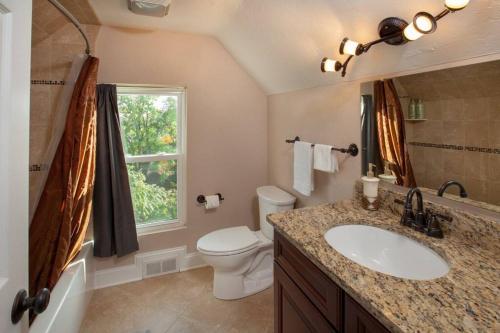 a bathroom with a sink and a toilet and a window at Stunning City Living Open Floor Plan in Pittsburgh