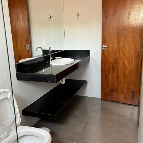 ein Bad mit einem Waschbecken und einem WC in der Unterkunft Residência Prado in Capitólio