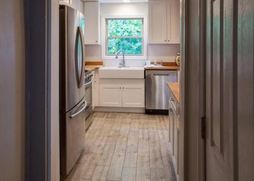 een keuken met witte kasten en een houten vloer bij Light and Bright Renovated Farmhouse in the City in Pittsburgh