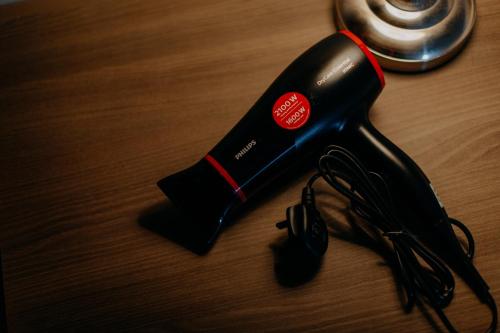 a black hair dryer sitting on a wooden table at Windmill Upon Hills Premium Suite By Rapi Stay in Genting Highlands