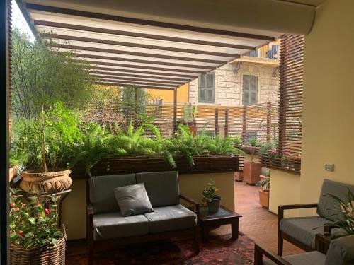 a patio with a couch and alot of plants at Appartamento con terrazza centrale e luminoso in Rome