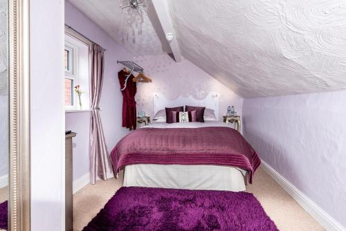 a bedroom with a purple bed in a attic at Glen Guest House in Blackpool