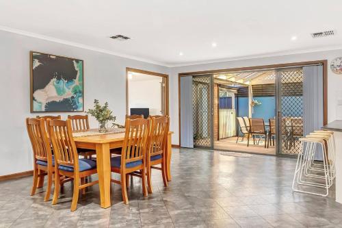 a dining room with a wooden table and chairs at Laidback Seaford Family Retreat 200m from Beach in Adelaide