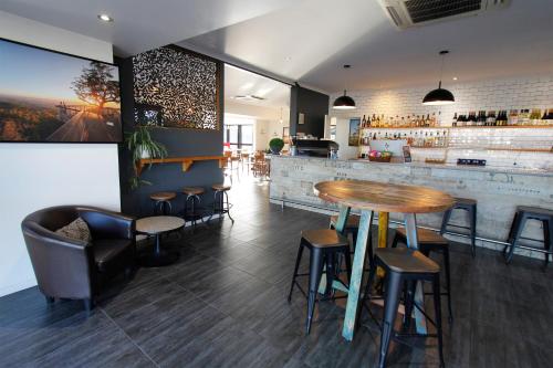 restauracja ze stołem i krzesłami oraz bar w obiekcie The Stirling Motel w mieście Rockhampton