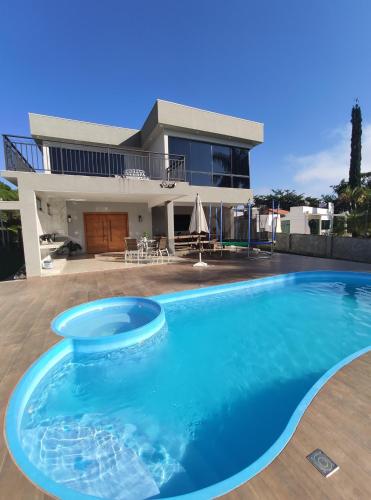 a swimming pool in front of a house at Casa Verales in Carmo do Cajuru