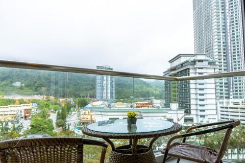 a table and chairs on a balcony with a view of a city at Windmill Upon Hills Premium Suite By Rapi Stay in Genting Highlands