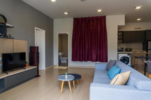 a living room with a blue couch and a television at Windmill Upon Hills Premium Suite By Rapi Stay in Genting Highlands