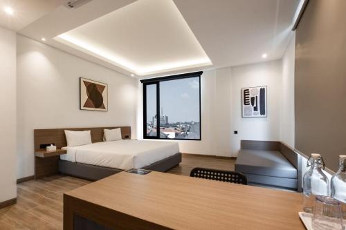 Pokój hotelowy z łóżkiem i biurkiem z biurkiem w obiekcie Assa Hotel w mieście Semarang