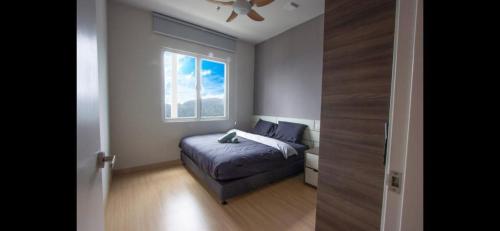 a small bedroom with a bed and a window at Windmill Upon Hills Premium Suite By Rapi Stay in Genting Highlands