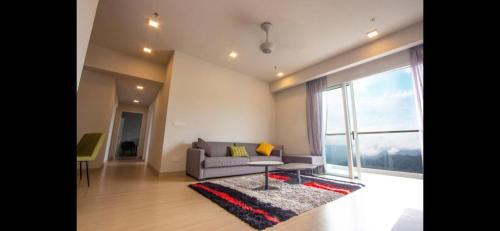 a living room with a couch and a large window at Windmill Upon Hills Premium Suite By Rapi Stay in Genting Highlands