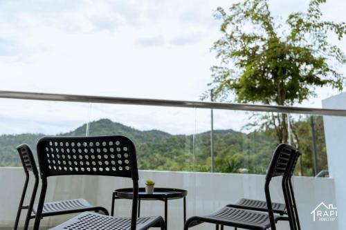 two chairs and a table on a balcony with a view at Windmill Upon Hills Premium Suite By Rapi Stay in Genting Highlands