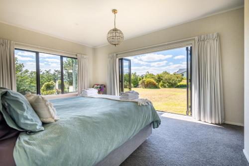 a bedroom with a bed and a large window at Big Inn Brunswick in Rotorua