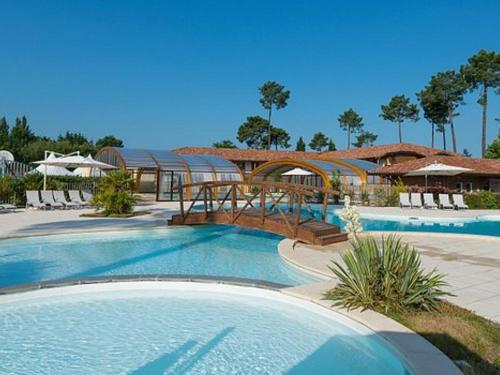 un complexe avec une piscine et un pont dans l'établissement Charmant apt à Parentis avec piscine, 4 pers, près du lac, ménage inclus - FR-1-319-444, à Parentis-en-Born