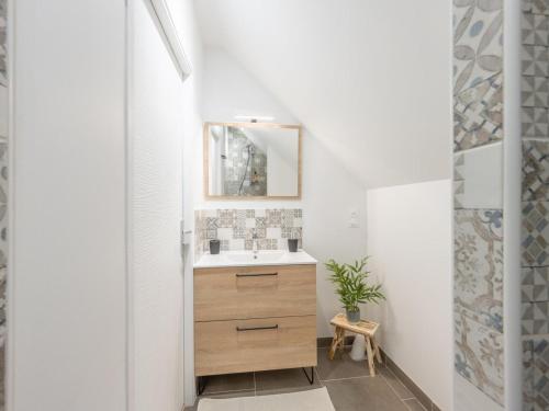 une salle de bain avec un lavabo et un miroir dans l'établissement Maison spacieuse 8 pers avec équipements modernes et garage, proche Compiègne et Parc Astérix - FR-1-526-43, à Sacy-le-Petit