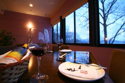 a table with a bottle of wine and a glass at Ame no Hi to Yuyake-Adult Only in Chitose