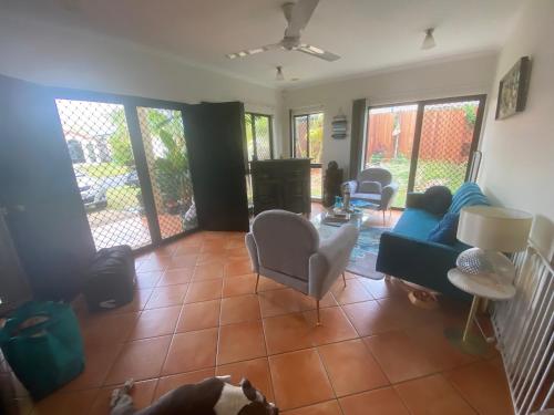 uma sala de estar com um sofá e cadeiras em Cairns Homestay em White Rock