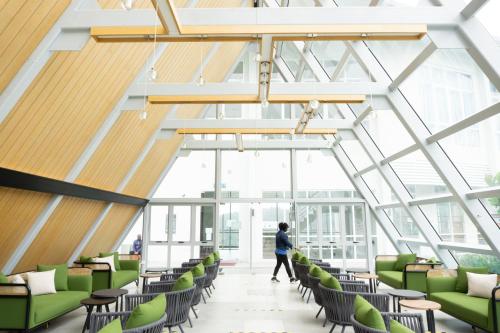 a person walking through a room with green chairs at Windmill Upon Hills Premium Suite By Rapi Stay in Genting Highlands