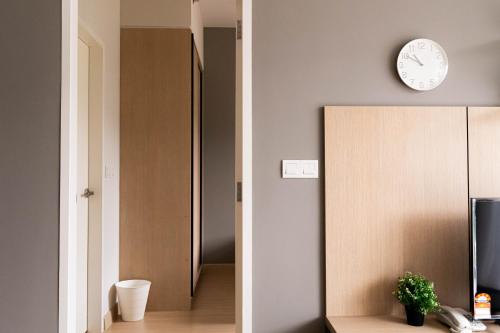 a room with a clock on the wall and a cabinet at Windmill Upon Hills Premium Suite By Rapi Stay in Genting Highlands