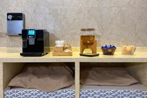 a table with a coffee maker and a drink on it at Yzhi Hotel - West Sports Road Metro Station in Guangzhou