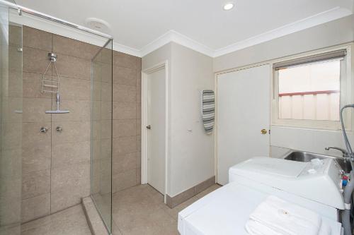 a bathroom with a shower and a toilet and a sink at Banksia Tourist Park in Perth