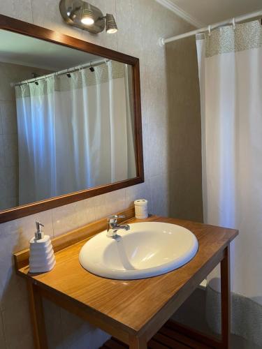 y baño con lavabo blanco y espejo. en Viento y montaña en San Carlos de Bariloche