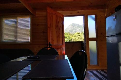 comedor con mesa, sillas y ventana en Alojamiento turístico WiFi, en Panguipulli