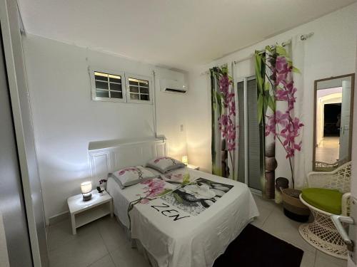 1 dormitorio blanco con 1 cama y 1 silla en Appartement Coeur de Papillon, en Baie-Mahault
