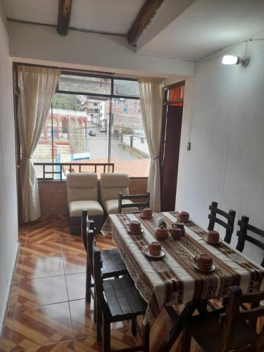 a dining room with a table and chairs and a couch at Casa Hospedaje"Los Capulies" in Carhuaz