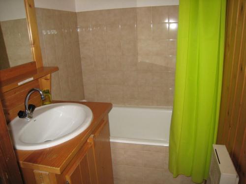 La salle de bains est pourvue d'un lavabo et d'un rideau de douche vert. dans l'établissement Studio La Clusaz, 1 pièce, 4 personnes - FR-1-459-120, à La Clusaz