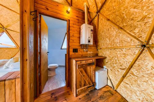 uma casa de banho numa tenda com um WC e um lavatório em GLAMPING TICA NATIVO em Villa Carlos Paz