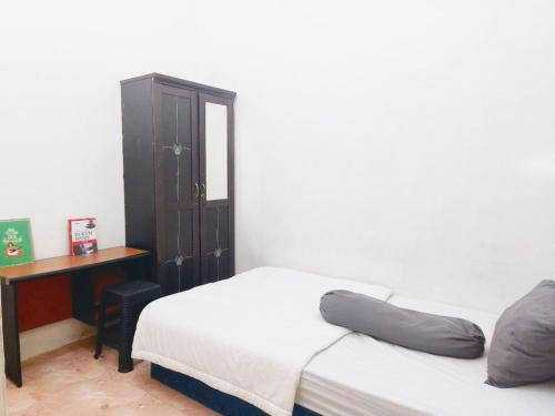 um quarto com 2 camas, uma mesa e uma secretária em Kost Griya Hikari by Ecommerceloka em Jakarta