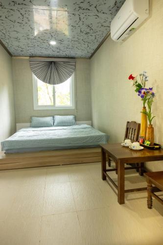 a bedroom with a bed and a window and a table at Halo Retreat in Hòa Bình