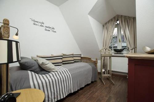 een slaapkamer met een bed, een tafel en een raam bij Ferienhaus-Hoppe-Wohnung-01 in Westerland