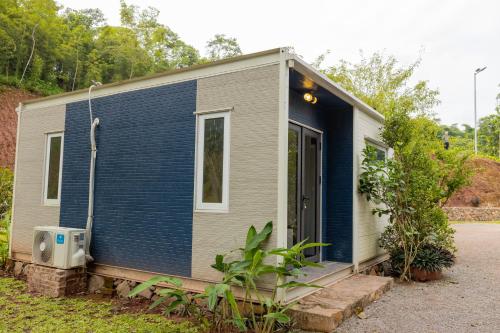 a tiny house with a blue and gray exterior at Halo Retreat in Hòa Bình