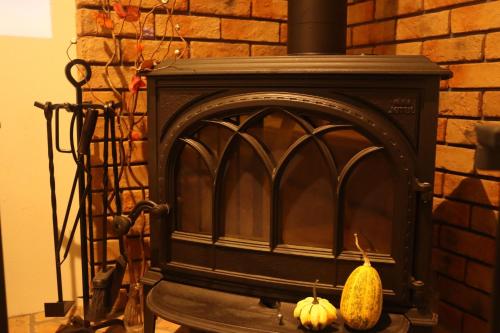 a fireplace with two pumpkins next to a brick wall at SAUNA FOREST CABIN 軽井沢 御代田 A棟 zen-asobi in Oiwake