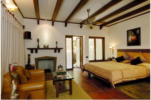 a bedroom with a bed and a couch and a fireplace at Ramsukh Resorts and Spa in Mahabaleshwar